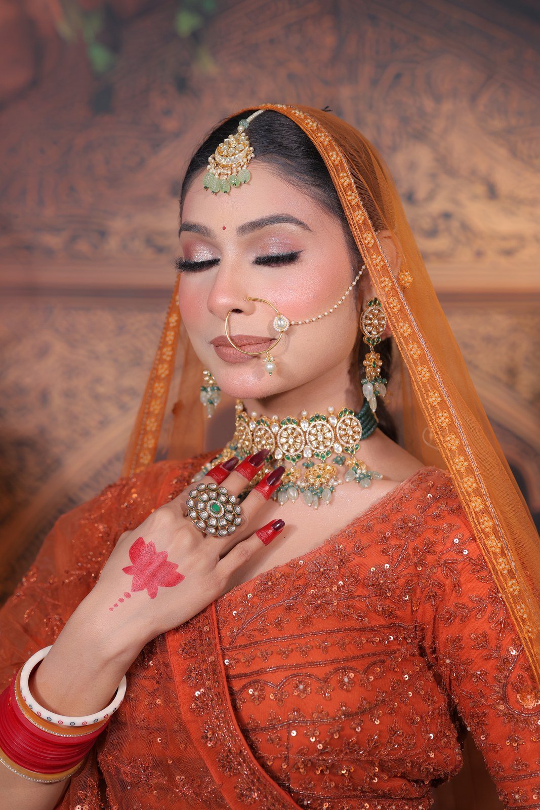 Bride in red lehenga with kundan jewellery and bridal makeup